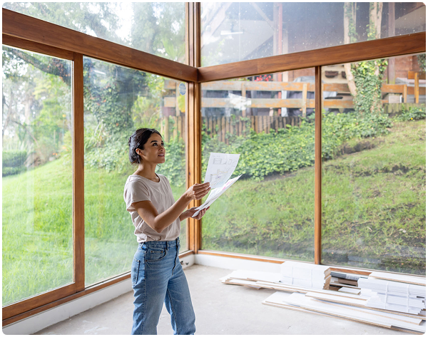 Woman examining plans in a sunlit room